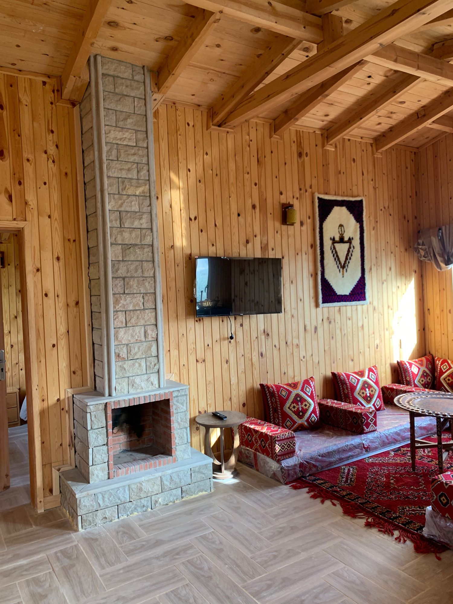 Cheminée en pierre dans le salon d'un chalet en bois