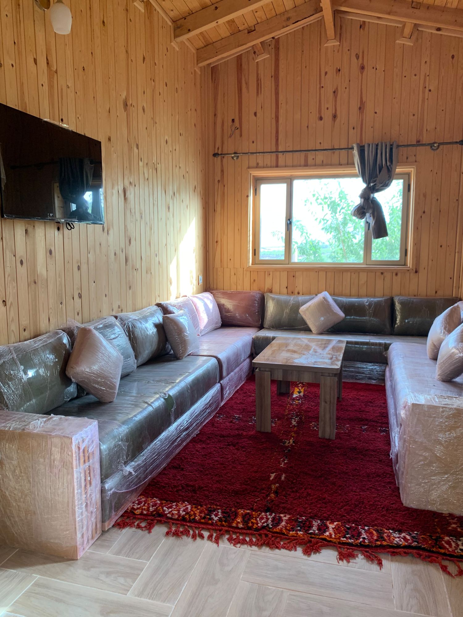 Grand salon en U sous une charpente en bois