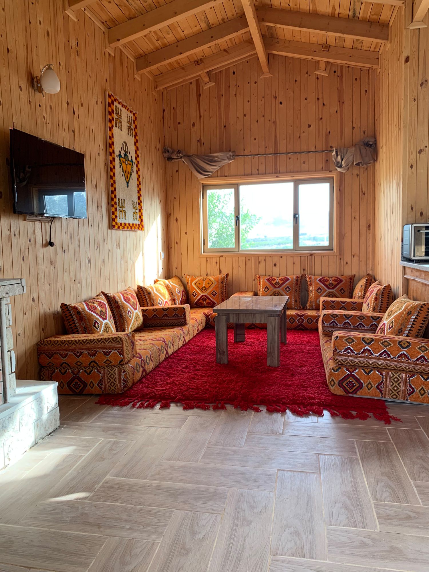 Salon marocain aux coussins safran dans un chalet en bois