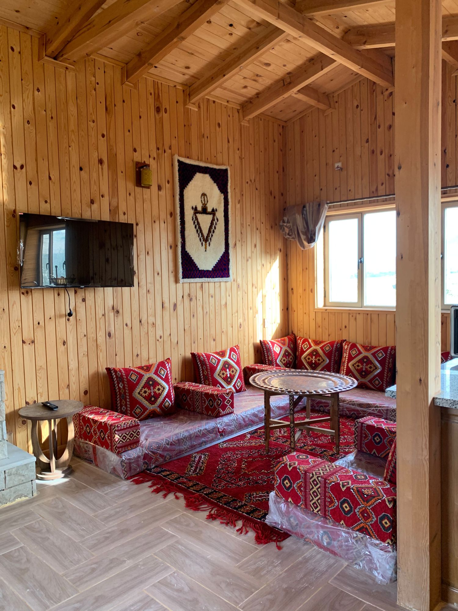 Salon rouge avec table en cuivre ciselé et tapis berbère