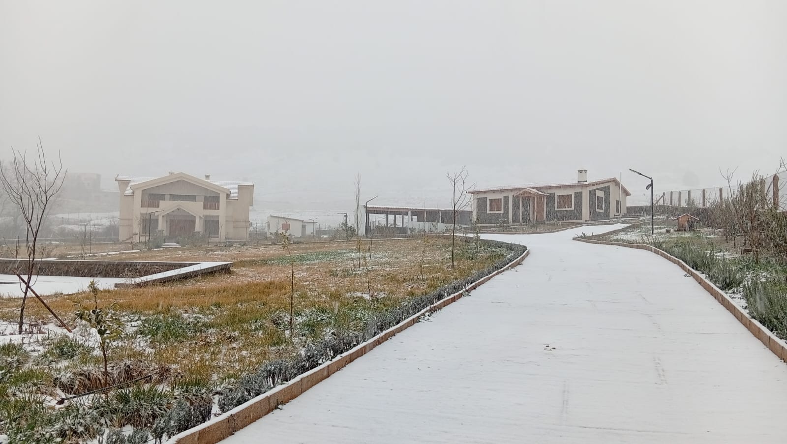 L'allée du domaine sous la neige, avec les villas au fond